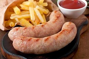 Chicken sausages grilled with a side dish of  french fries photo