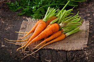 Fresh  carrots on old  wooden background photo