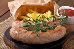 Chicken sausages grilled with a side dish of  french fries photo