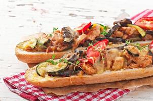 Big sandwich with roasted vegetables  with cheese and thyme on old wooden background photo