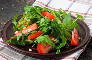 ensalada con rúcula, tomates y piñones foto