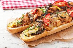 Big sandwich with roasted vegetables  with cheese and thyme on old wooden background photo