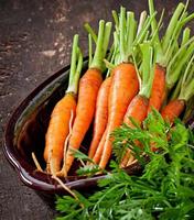 Fresh  carrots on old  wooden background photo
