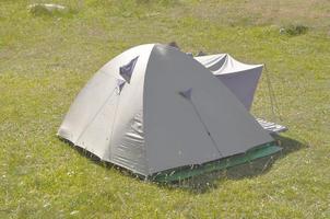 A fabric camping tent shelter in a field photo