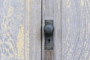 Black old door knob on wooden doors, vintage style. The doors close and has color abrasion. photo