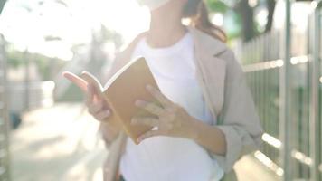 primer plano gesto joven hermosa mujer rubia asiática leyendo en una breve nota personal para verificar la lista para hacer a continuación o la lista de clientes para reunirse hoy, toque memorable de papel, libro de papel reciclable video