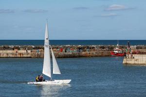 staithes, North Yorkshire, Reino Unido, 2010. Gran catamarán blanco navegando hacia el puerto de staithes foto