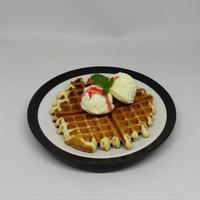 Waffle with Ice Cream in a plate on the table photo