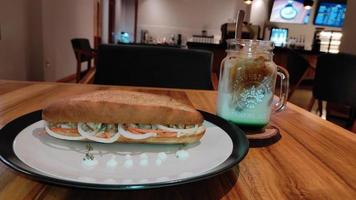 perritos calientes en un plato con café con leche helado en una mesa de café foto