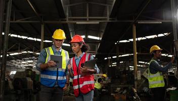 The foreign chief engineer came to inspect the old mechanical factory. There is an African female mechanic explaining details and progress reports photo