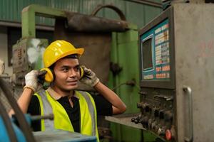 Asian mechanic working in a mechanical factory Repairing old machines photo