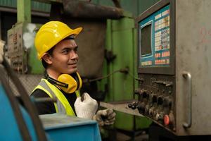 Asian mechanic working in a mechanical factory Repairing old machines photo