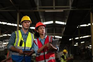 The foreign chief engineer came to inspect the old mechanical factory. There is an African female mechanic explaining details and progress reports photo