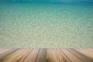 el suelo de madera con vistas al paisaje del hermoso fondo marino cristalino. foto