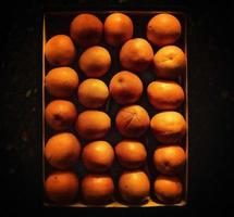 Multiple oranges ordered precisely on a dark balcony photo