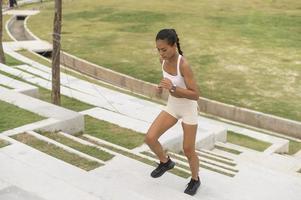 una joven mujer fitness en ropa deportiva haciendo ejercicio en el parque de la ciudad, saludable y estilos de vida. foto
