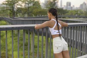 A young fitness woman in sportswear exercising in city park, Healthy and Lifestyles. photo