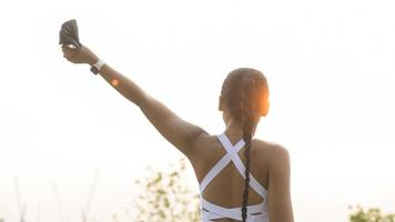 mujer joven fitness en ropa deportiva quitándose la máscara facial mientras hace ejercicio en el parque de la ciudad, la salud y los estilos de vida. foto