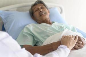 médico sosteniendo la mano del paciente mayor en el hospital, atención médica y concepto médico foto