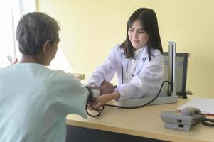 El paciente masculino asiático mayor está consultando y visitando al médico en el hospital. foto