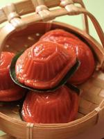 Close up view of red tortoise cake in small bamboo basket. photo