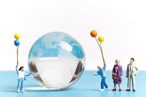 Miniature people kid holding balloon with crystal Globe photo