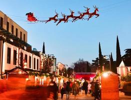 Street view crowds of people with children on xmas market on Christmas day. Celebrations and city holidays spirit photo