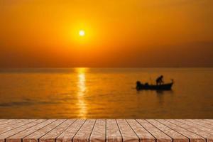 mesa de madera vacía en una hermosa puesta de sol borrosa foto