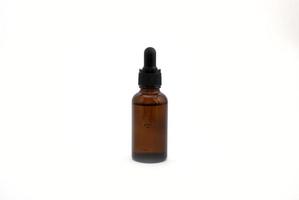 Serum in a brown glass bottle on a white background.