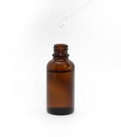 Serum in a brown glass bottle on a white background. photo