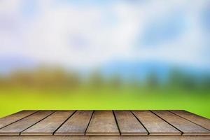 mesa de madera y desenfoque de belleza en un día soleado en el campo de arroz con cielo y montañas como fondo. foto