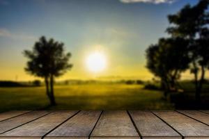 Wooden table and blur of beauty on a sunset day on a field with sky and mountains in the background. photo