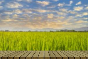 Wooden table and blur of beauty on a sunset day on a field with sky and mountains in the background. photo