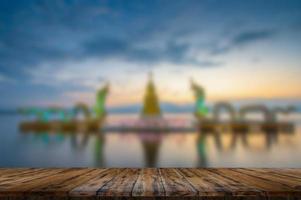 Empty wooden table on beautiful lake sunset photo