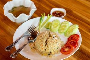 Crab meat fried rice and vegetable on a wooden table. photo