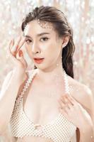 Beautiful young asian woman with clean fresh skin with pearls on glitter background. Face care, Facial treatment, beauty and spa, Cute Asian women portrait. photo