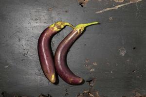 Raw eggplant on wood background. photo