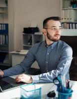 hombre de negocios trabajando en su computadora portátil en una oficina foto