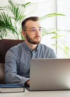 hombre de negocios trabajando en su computadora portátil en una oficina foto