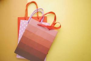 top view of multi color shopping bag on orange background photo