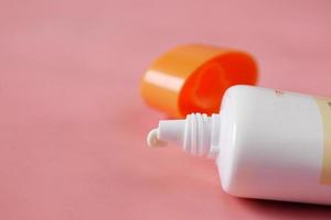 Close up of sunscreen cream in a pink container photo