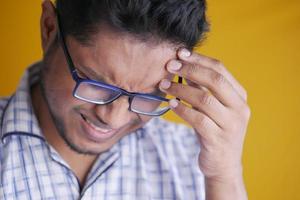 Young man suffering headache, close up photo