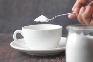 pouting white sugar in a tea cup photo