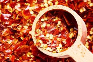 red chili pepper flakes in a spoon close up photo
