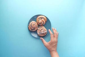 top view of hand pick cinnamon danish roll on table photo