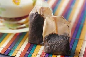 tea bags and yellow color mug on table photo