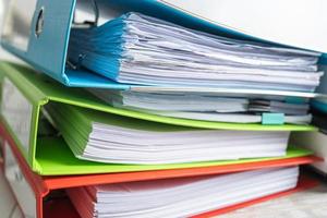 File Folder Binder stack of multi color on table in business office. photo