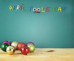 Happy April fools day - colorful text made from crayon on green background with many party ball photo