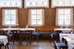 Tables and chairs arranged in restaurant at luxurious resort on sunny day photo