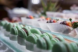 Close-up of green macaroons and chocolate strawberry on counter at ski resort photo